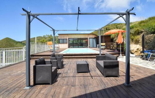 a deck with a pool and chairs and an umbrella at Villa Al Monte in Mondragone