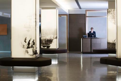 a woman sitting at a desk in an office with a laptop at Du Lac Et Du Parc Grand Resort in Riva del Garda