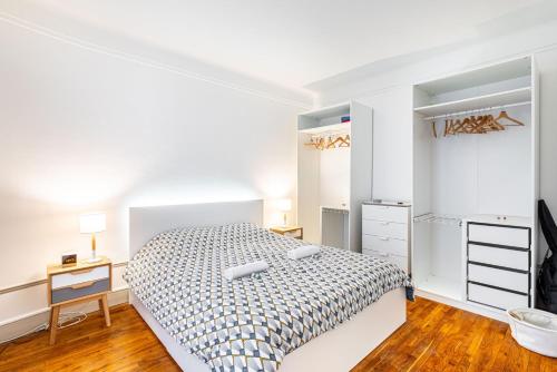 une chambre blanche avec un lit et une commode dans l'établissement GuestReady - Bel Apt charmant près de Montmartre, à Paris