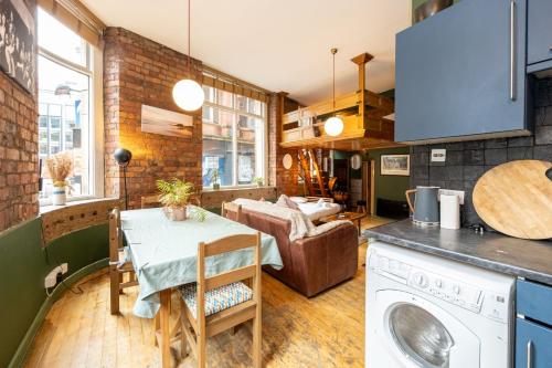 een keuken en een woonkamer met een tafel en een wasmachine bij GuestReady - Comfortable stay in Manchester in Manchester