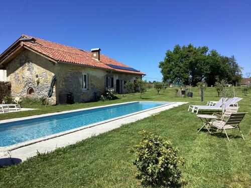 une villa avec piscine devant une maison dans l'établissement Ferme du Peyronin, à Heugas