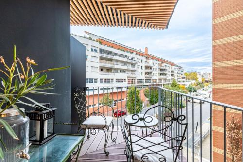 d'un balcon avec des chaises et une vue sur un bâtiment. dans l'établissement GuestReady - Delight and Peace in Issy, à Issy-les-Moulineaux
