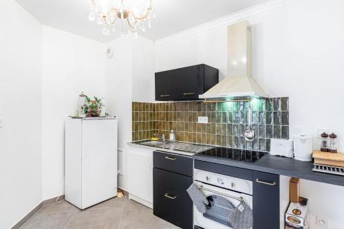 une cuisine avec une cuisinière et un réfrigérateur dans l'établissement GuestReady - Delight and Peace in Issy, à Issy-les-Moulineaux