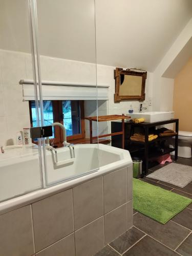 une grande salle de bain avec une baignoire et un lavabo dans l'établissement La Baudinière, Chambre La Dorée, à Boyer