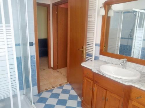 a bathroom with a sink and a glass shower door at 2 bedrooms apartement with lake view enclosed garden and wifi at San Mauro Pascoli 3 km away from the beach in San Mauro Pascoli