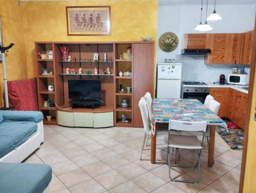 a living room with a table and a kitchen at 2 bedrooms apartement with lake view enclosed garden and wifi at San Mauro Pascoli 3 km away from the beach in San Mauro Pascoli