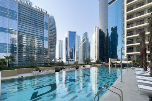uma grande piscina numa cidade com edifícios altos em GuestReady - Business Bay Beauty near Dubai Canal em Dubai