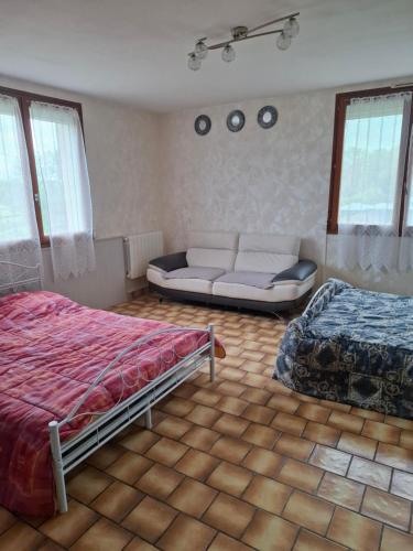 a bedroom with two beds and a couch in it at campagne in Saint-Pardoux-le-Neuf