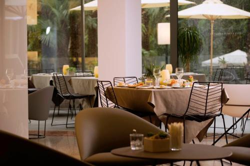a dining room with tables and chairs and windows at Du Lac Et Du Parc Grand Resort in Riva del Garda