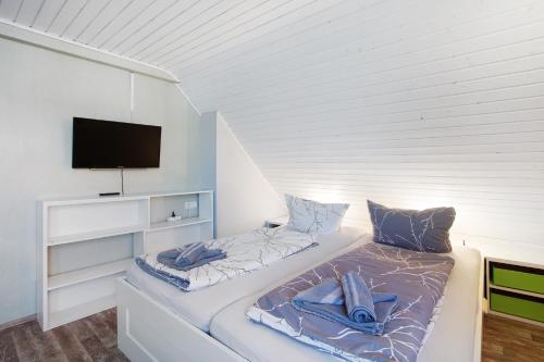 a white room with a bed with a tv on it at Nette Hütte in Bad Säckingen