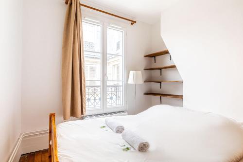 een slaapkamer met een bed en een raam bij GuestReady - Parisian Perch with Eiffel Tower View in Parijs