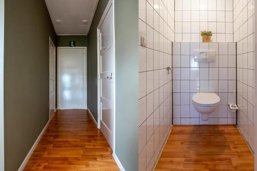 een kleine badkamer met een toilet en een deur bij Hello Zeeland - Essenhoeve 2 Rosa Rugosa in Cadzand