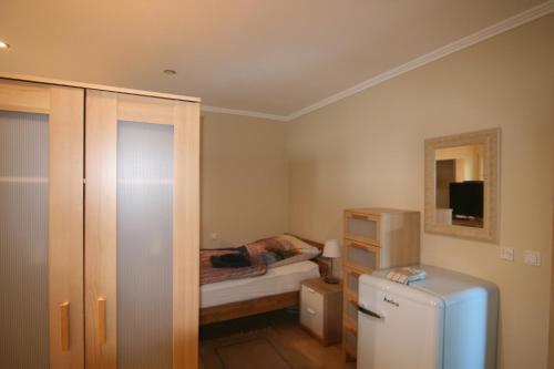 a small bedroom with a bed and a refrigerator at Haus Pleidelsheim in Pleidelsheim