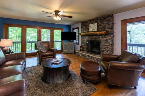 a living room with leather furniture and a fireplace at Lakefront Point Retreat on Nantahala Lake with Dock in Topton