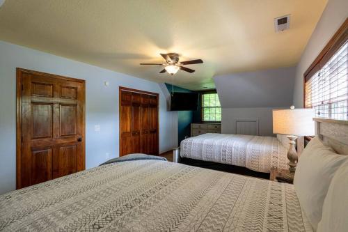 a bedroom with two beds and a ceiling fan at Lakefront Point Retreat on Nantahala Lake with Dock in Topton