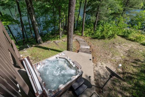 a hot tub sitting on the side of a house at Lakefront Point Retreat on Nantahala Lake with Dock in Topton