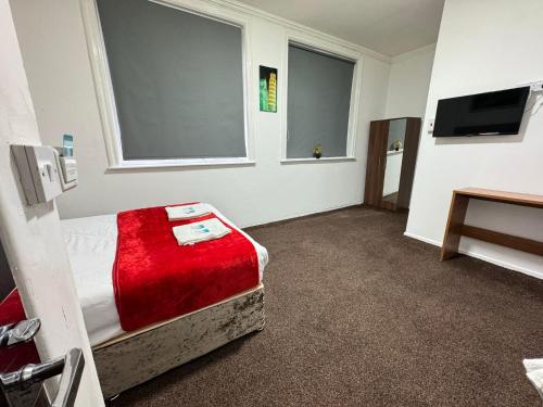 a bedroom with a bed with a red blanket at Parkview Residence in Manchester