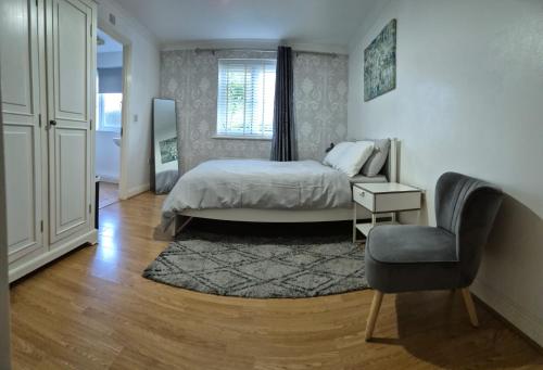 a bedroom with a bed and a chair at Spacious 2 bedroom 2 Bathroom Flat in Hatfield near Hertfordshire University with Private Car Park Sleeps 5-6 in Hatfield