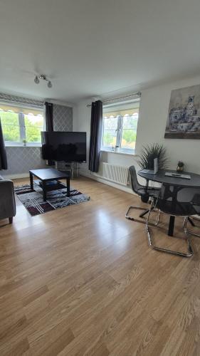 a living room with a table and a television at Spacious Ground floor 2 bedroom 2 Bathroom Flat in Hatfield near Hertfordshire University Private Car Park Sleeps 5-6 in Hatfield