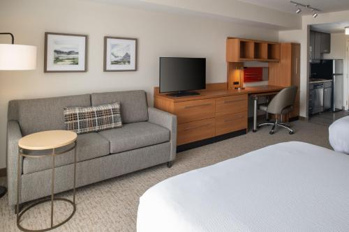 a living room with a couch and a television at TownePlace Suites Richland Columbia Point in Richland
