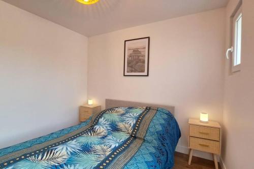 une chambre avec un lit et deux tables de nuit dans l'établissement Marbella, agreable appartement a Reims, à Reims