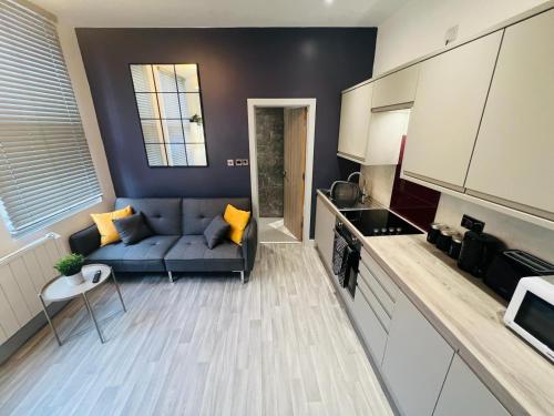a living room with a blue couch in a kitchen at WhiskAwayStays - Foregate Street - Apartment 1 in Worcester
