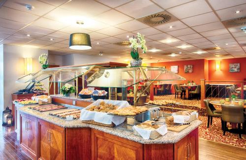 a buffet line with various pastries and other food at Leonardo Hotel Hamburg City Nord in Hamburg