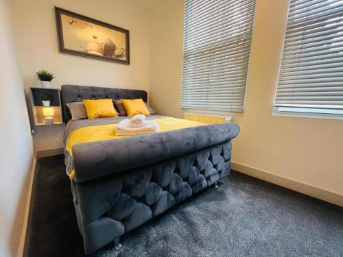 a bedroom with a bed with a blue tufted headboard at WhiskAwayStays - Foregate Street - Apartment 1 in Worcester