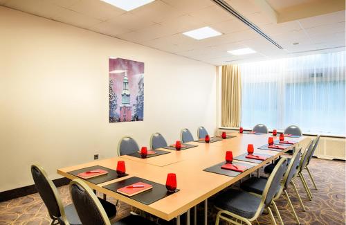 a conference room with a long table and chairs at Leonardo Hotel Hamburg City Nord in Hamburg