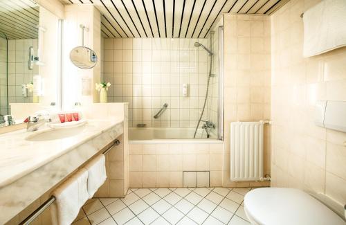 ハンブルクにあるレオナルド ホテル ハンブルク シティ ノードのバスルーム(バスタブ、トイレ、シンク付)