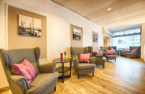 a waiting room with chairs and a table at Leonardo Hotel Hamburg City Nord in Hamburg