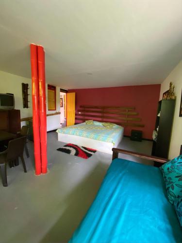 a bedroom with two beds and a red wall at Finca hotel tierra grata in Montenegro