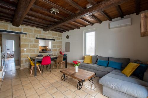 un salon avec un canapé et une table dans l'établissement Maison familiale à 2 min à pied de l'Institut A Armand Calme Jeux babyfoot Jacuzzi Proche Mer, à Saint-Laurent-dʼAigouze