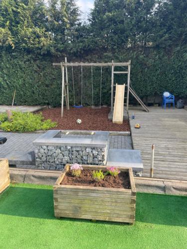 a garden with a sandbox and a swing at Le Loft in Stoumont