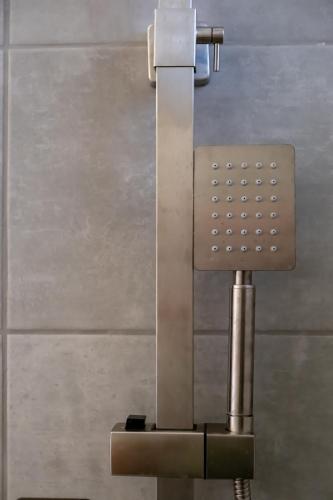 a metal object in a bathroom with a wall at One House Pythagoreio in Pythagoreio