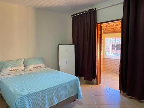 - une chambre avec un lit et une porte coulissante en verre dans l'établissement Casa Freire Mafra, à Rio de Contas