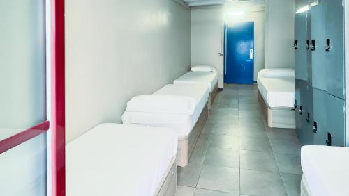 バルセロナにあるイデアル ユース ホステルの白いベッドが並ぶ部屋