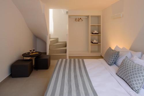 a bedroom with a bed and a small table at Kalestesia Suites in Akrotiri