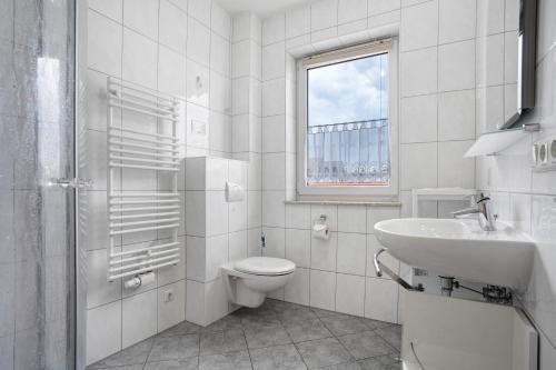 a white bathroom with a toilet and a sink at Ilse - Ferienwohnungen Zinnowitz in Zinnowitz