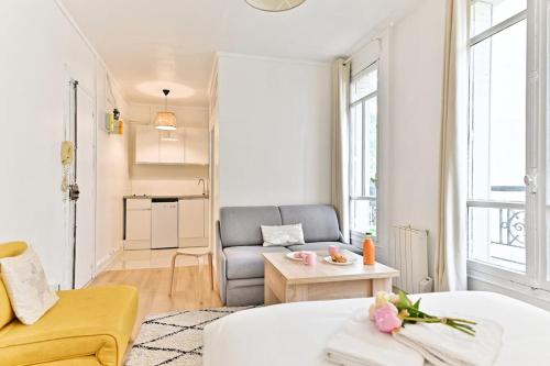 un salon avec un canapé et une table dans l'établissement Studio paisible Parc des Buttes-Chaumont, à Paris