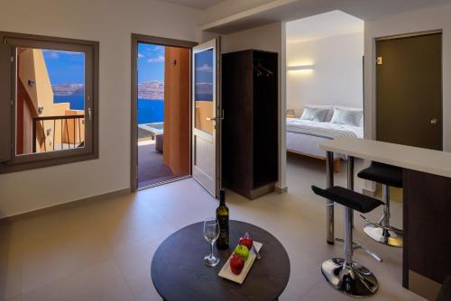 a room with a bed and a table with wine glasses at Kalestesia Suites in Akrotiri