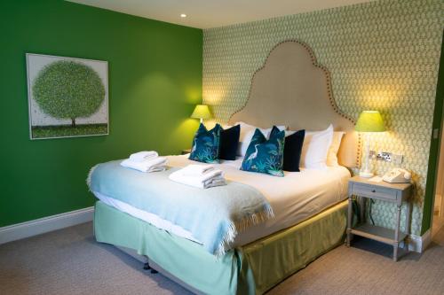 a bedroom with a large bed with blue pillows at The Swan Hotel and Spa in Newby Bridge