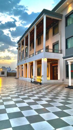 a building with a checkered floor in front of it at The Girvar Hotel, Barr in Beāwar