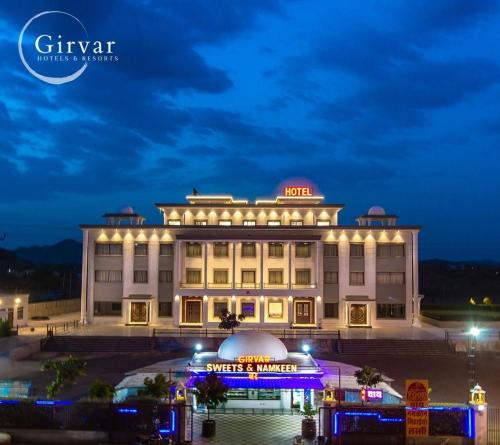 a large building with lights on it at night at The Girvar Hotel, Barr in Beāwar
