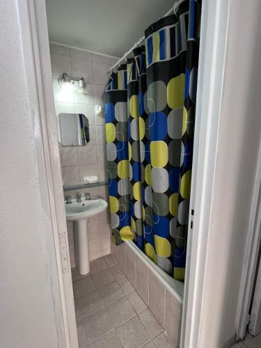 een badkamer met een wastafel en een douchegordijn bij Depto25nuevo in Mendoza