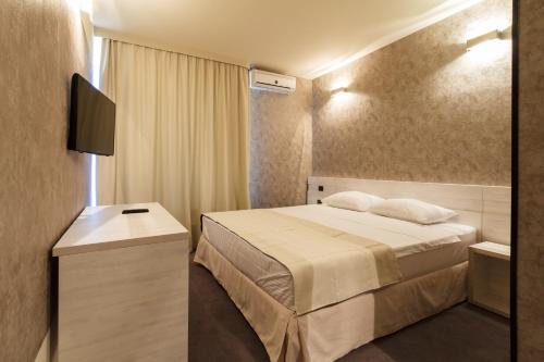 pokój hotelowy z łóżkiem i telewizorem w obiekcie YMY HOTELS Târgu Jiu w mieście Târgu Jiu