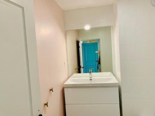 La salle de bains est pourvue d'un lavabo blanc et d'une porte bleue. dans l'établissement Très bel appartement rénové, grande terrasse vue mer, à Marseille
