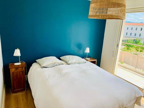 - une chambre bleue avec un lit blanc et une fenêtre dans l'établissement Très bel appartement rénové, grande terrasse vue mer, à Marseille