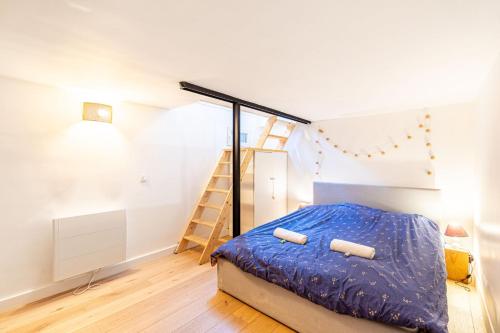 - une chambre avec un lit avec des draps bleus et une échelle dans l'établissement GuestReady - Charming nest in Porte de Clichy, à Paris