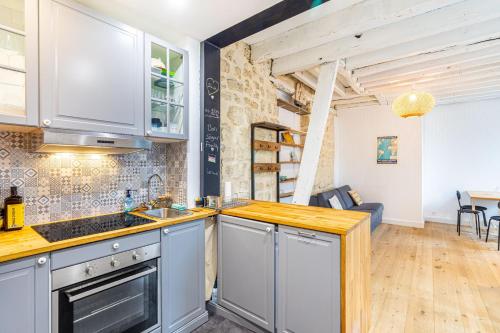 une cuisine avec un évier et une cuisinière dans l'établissement GuestReady - Charming nest in Porte de Clichy, à Paris